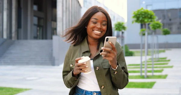 Afroameričanka Radostná Mladá Stylová Žena Sledující Video Smartphonu Popíjející Horký — Stock fotografie