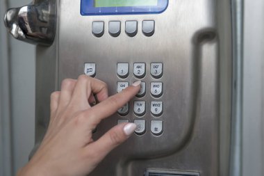 Genç kadın bir telefon kulübesinden kutusunu arama yapma