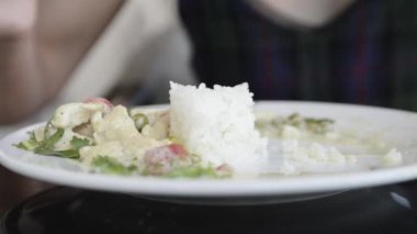 close-up footage of woman eating rice with vegetables
