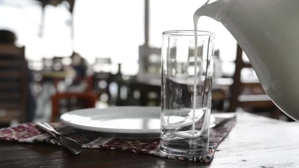 新鮮な冷たいヨーグルトを飲む ガラスの水差しからアイランを注ぐ ギリシャ ヨーグルト 日焼け クミスクチン — ストック動画