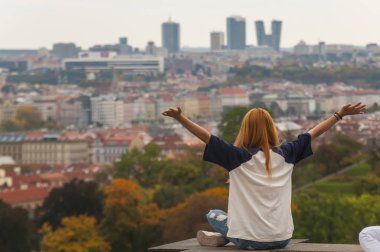 Kadın havaya kalkar ve şehre yukarıdan bakar.