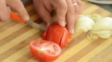 Bir domates ahşap tahta kesme pişirin. Bir salata hazırlık.