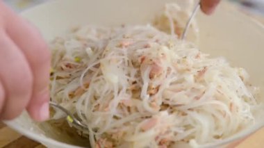 man cooking tuna and noodles salad