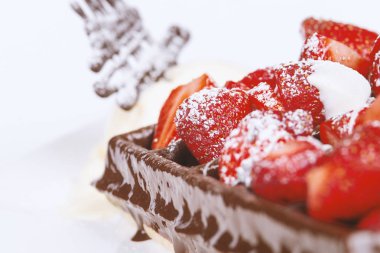 Dondurma, koyu çikolata ve beyaz arka plan üzerinde çilek ile Belçika waffle