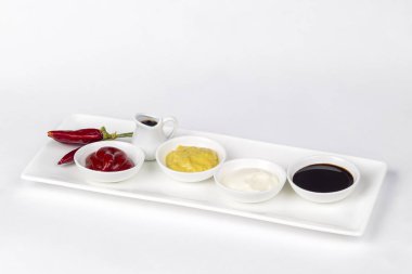 Mayonez, ketçap, hardal, soya sosu ve beyaz zemin üzerine biber