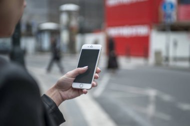 Kadın sokakta telefon tutarak. Cep telefonu ile yakın çekim kadının el