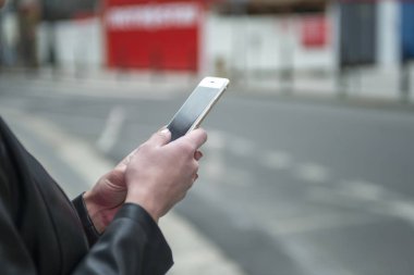 Kadın sokakta telefon tutarak. Cep telefonu ile yakın çekim kadının el