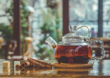 Cam çaydanlık ahşap zemin üzerine tarçın ile sıcak baharatlı çay