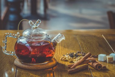 Cam çaydanlık ahşap zemin üzerine tarçın ile sıcak baharatlı çay