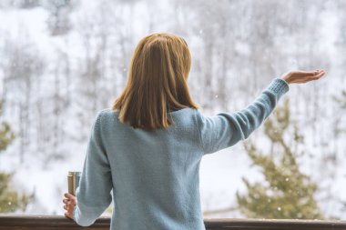 Kadın bir termos şişe elinde bir kış ormanda arka planda