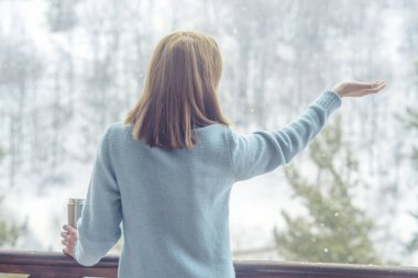 Kadın bir termos şişe elinde bir kış ormanda arka planda