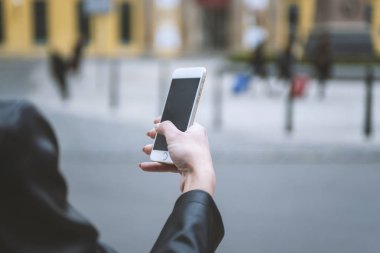 Kadın sokakta telefon tutarak. Cep telefonu ile yakın çekim kadının el