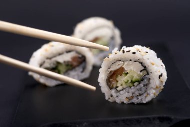 Somon, karides, avokado ve krem peynirli Philadelphia usulü suşi. Suşi menüsü. Japon yemeği..