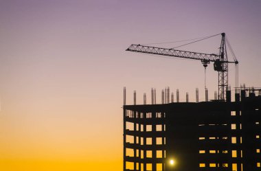 Endüstriyel makine ve inşaat vinç. Vinçler ve gökdelen yapım aşamasında, şehir manzarası, günbatımı, gündoğumu bina inşaat alanı altında.
