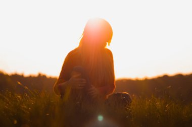 Genç kadın gündoğumu arka plan üzerinde yoga yapıyor. Sanatsal tonlama.