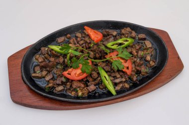 Bir demir plaka üzerinde kızarmış et parçaları. Asya mutfağı