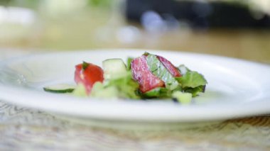 kişi çatal ve bıçak ile taze sebze salatası yiyor