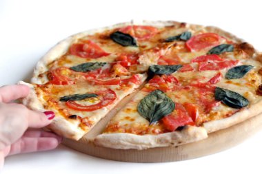 kadın beyaz bir arka planda masa tahtasında lezzetli sebze pizza bir parça alır