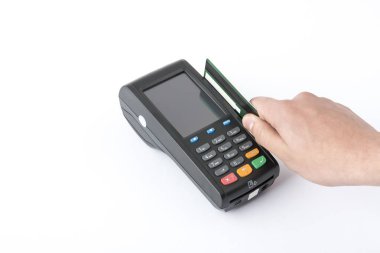 Terminalin önünde beyaz arka planda bir kredi kartı tutuyor..