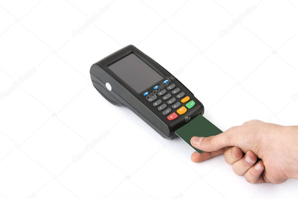 holds in hand a credit card in front of the terminal on white background.