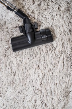 Bir kalın kazık beyaz carpet.still hayat koyu tonu vakumlama sırasında kullanılan modern elektrikli süpürge Başkanı yakın çekim.