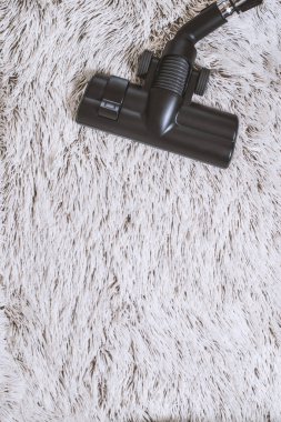 Bir kalın kazık beyaz carpet.still hayat koyu tonu vakumlama sırasında kullanılan modern elektrikli süpürge Başkanı yakın çekim.