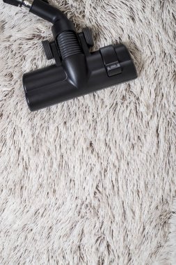 Bir kalın kazık beyaz carpet.still hayat koyu tonu vakumlama sırasında kullanılan modern elektrikli süpürge Başkanı yakın çekim.