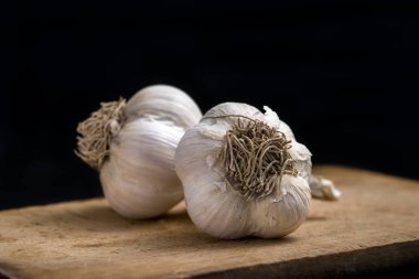 Sarımsak tahtada, siyah arka planda.