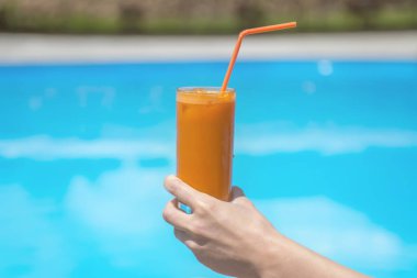 bilardo masasının yanında bir bardakta meyve suyu.