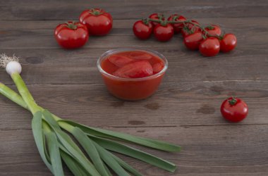 Ahşap bir arka plan üzerinde baharat ile kendi suyu bütün konserve domates