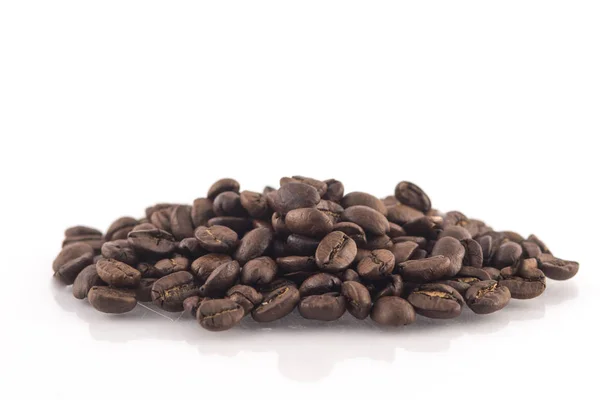烘培的咖啡豆桩在白色背景上 — 图库照片
