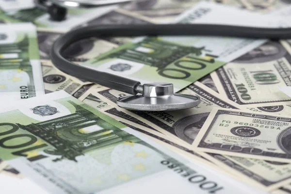 medical stethoscope on dollars and euro banknotes