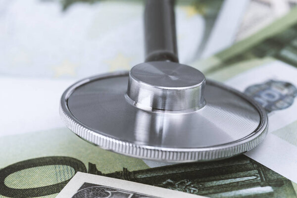 medical stethoscope on dollars and euro banknotes