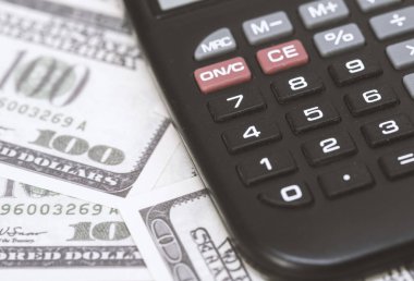 Birkaç dolar ve masa üzerinde bir hesap makinesi, finans ve tasarruf. İş konsepti