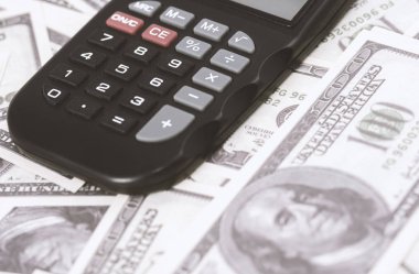 Birkaç dolar ve masa üzerinde bir hesap makinesi, finans ve tasarruf. İş konsepti