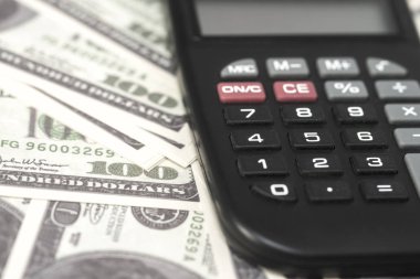 Birkaç dolar ve masa üzerinde bir hesap makinesi, finans ve tasarruf. İş konsepti