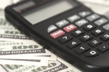 Birkaç dolar ve masa üzerinde bir hesap makinesi, finans ve tasarruf. İş konsepti