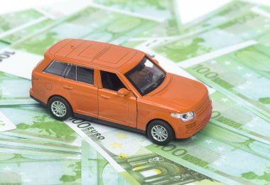 turuncu araba ve para, euro ve dolar. sigorta kavramı