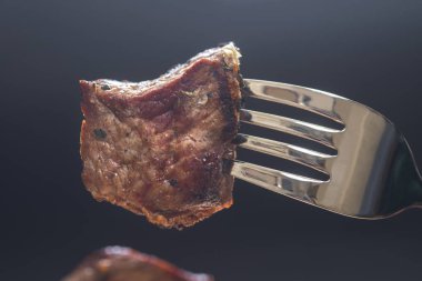 Çatal, koyu arka plan üzerinde et parçası