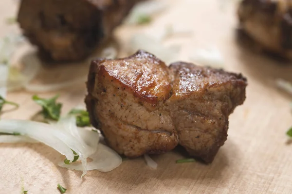 Stukjes varkensvlees kebab op een houten bord — Stockfoto