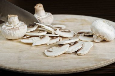 Ahşap masada kesme mantar pişirmek