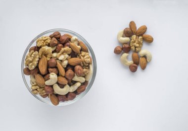 Beyaz bir arka plan üzerinde bir kapta karışık fındık.