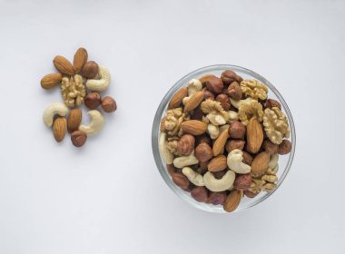 Beyaz bir arka plan üzerinde bir kapta karışık fındık.