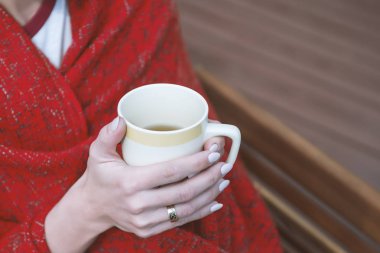 Genç kız ekose elinde çay ile sarılmış