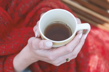 Genç kız ekose elinde çay ile sarılmış