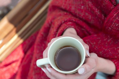 Genç kız ekose elinde çay ile sarılmış