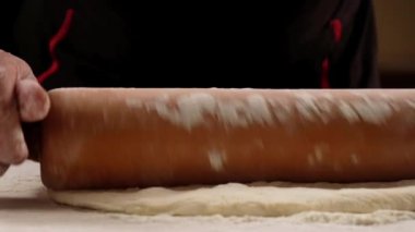Cook bir hamur dağıtSın. Eller yakın çekim . Yavaş çekim. Fırıncı pizza hazırlama için hamur yoğurunur. Şef aşçı ahşap masada pasta pişirme için hamur yapma. Süreç hazırlık ev yapımı pasta. Pişirme makarna, spagetti, khachapuri, gıda konsepti