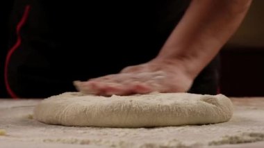 Baker kneading dough for pizza calzone preparation. Chef cook making dough for baking pie on wooden table. Process preparation homemade pastry. Cooking khachapuri, food concept