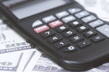Birkaç dolar ve masa üzerinde bir hesap makinesi, finans ve tasarruf. İş konsepti