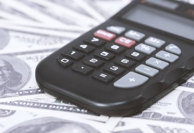 Birkaç dolar ve masa üzerinde bir hesap makinesi, finans ve tasarruf. İş konsepti